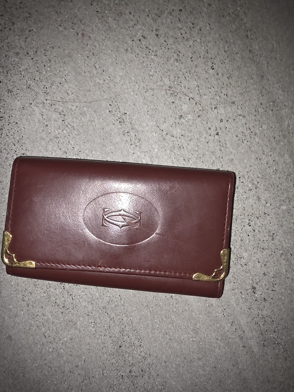 Cartier burgundy leather wallet with gold corner accents